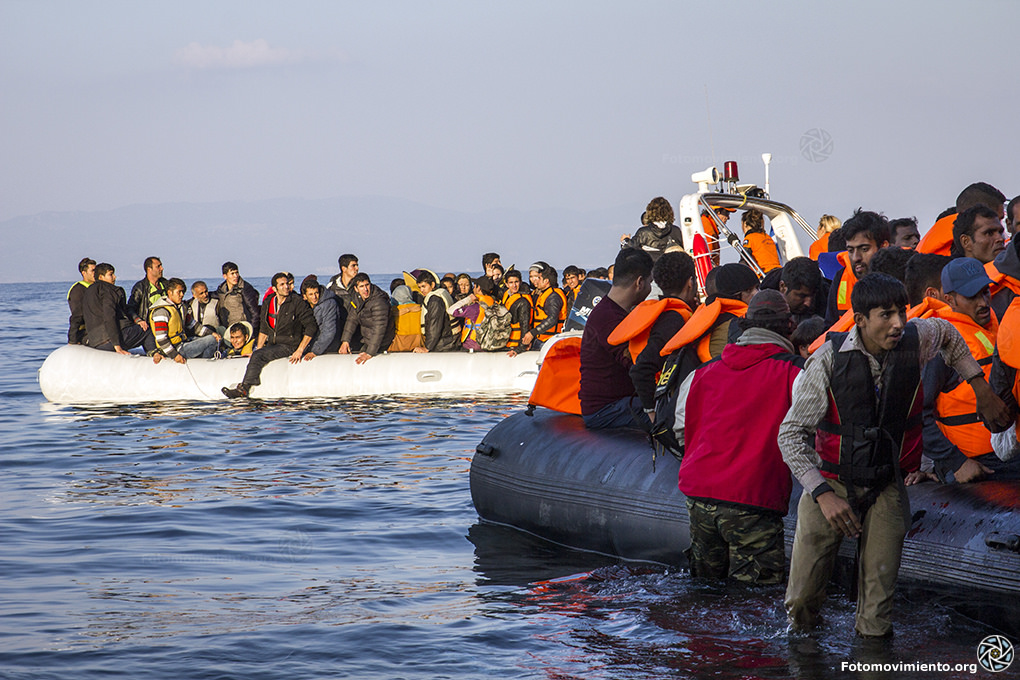 Dos enormes grupos de personas refugiadas en dos botes. Tienen chalecos salvavidas