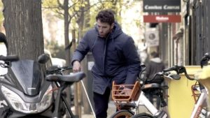 Una persona con bastón blanco detrás de bicis